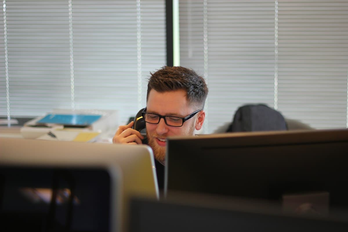Business owner taking a phone call at his desk in an open-plan office